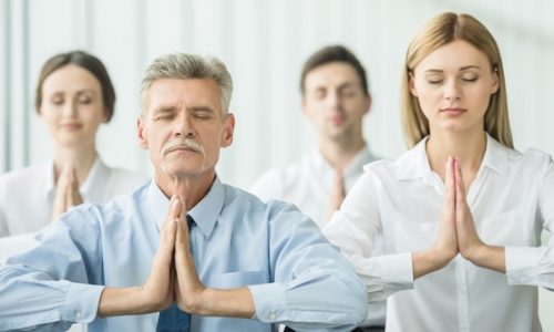 Führungskräfte aus verschiedenen Generationen strahlen Selbstvertrauen und Zusammenhalt aus – Symbol für ganzheitliches Gesundheitsmanagement und gesunde Unternehmenskultur.